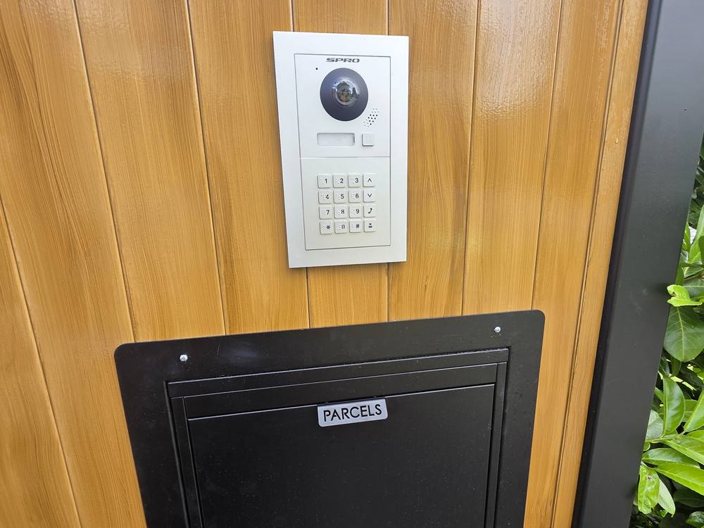 A hard-wired video door intercom and parcel box fitted to a timber front door