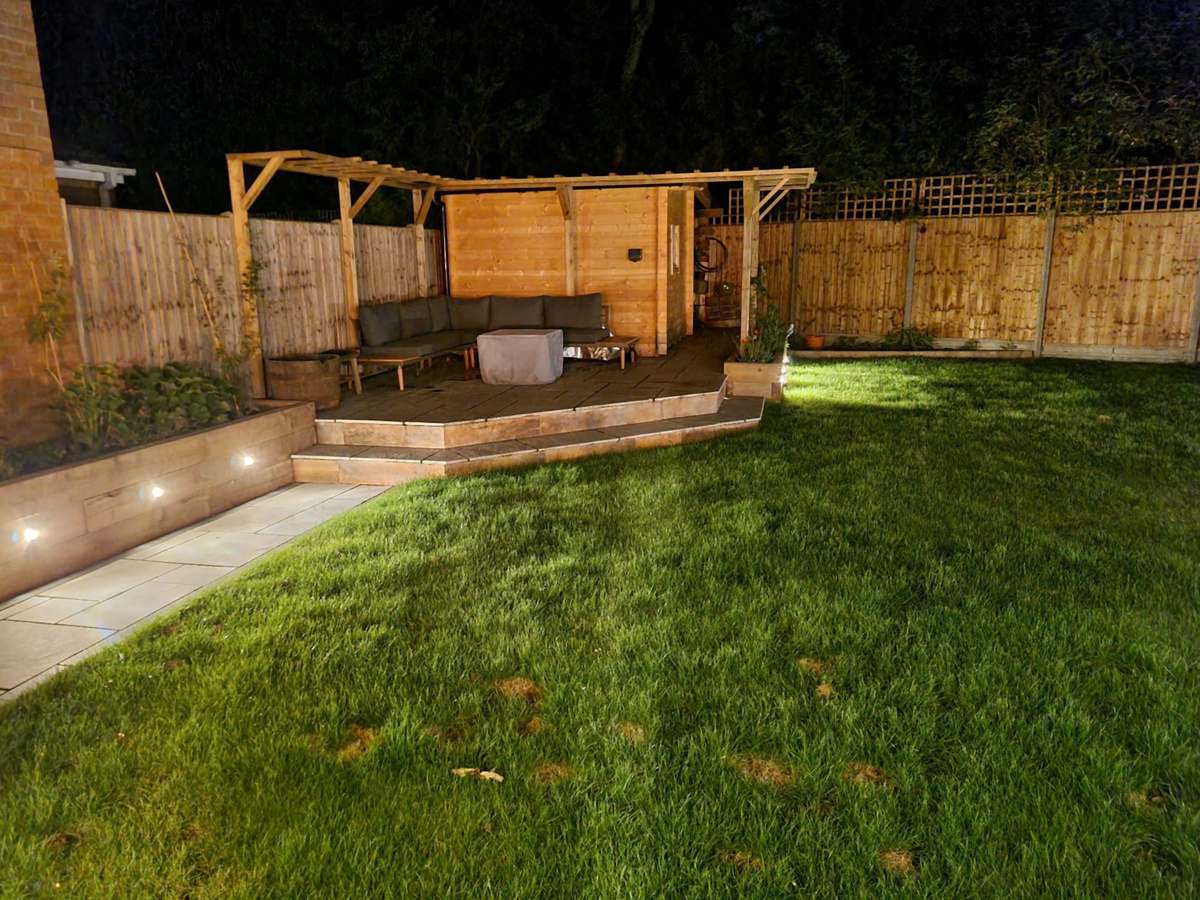 Low-level LED step lights illuminating a garden patio and pergola at night